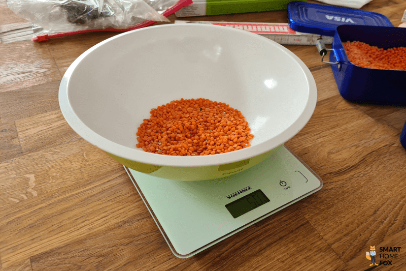 Грязь взвешивается на весах во время испытания мощности всасывания Dreame L20 Ultra.